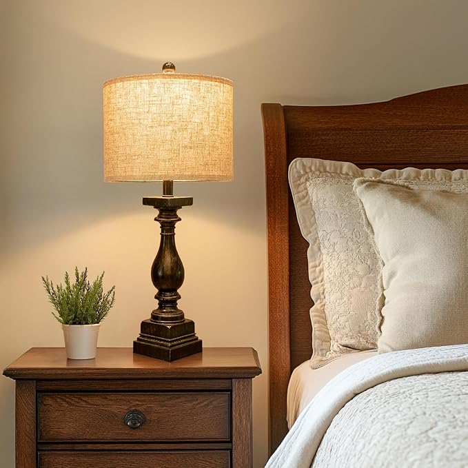 Bedside table lamp with beige fabric shade and dark black turned base, power cord
