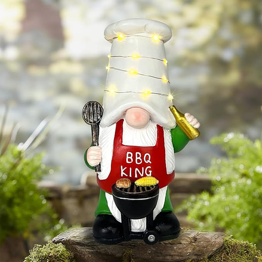 Outdoor garden gnome statue with chef hat, BBQ grill, and warm solar string lights