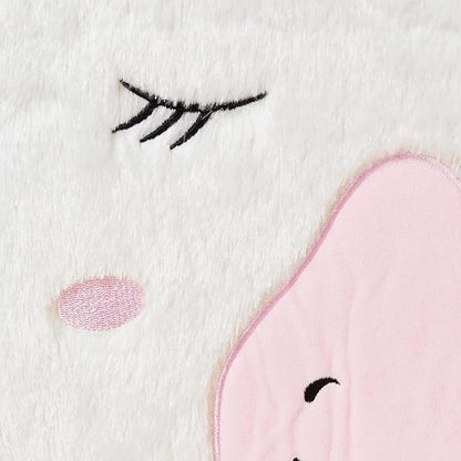 Unicorn plush toddler chair close-up of eyelash and pink heart patch on white fabric