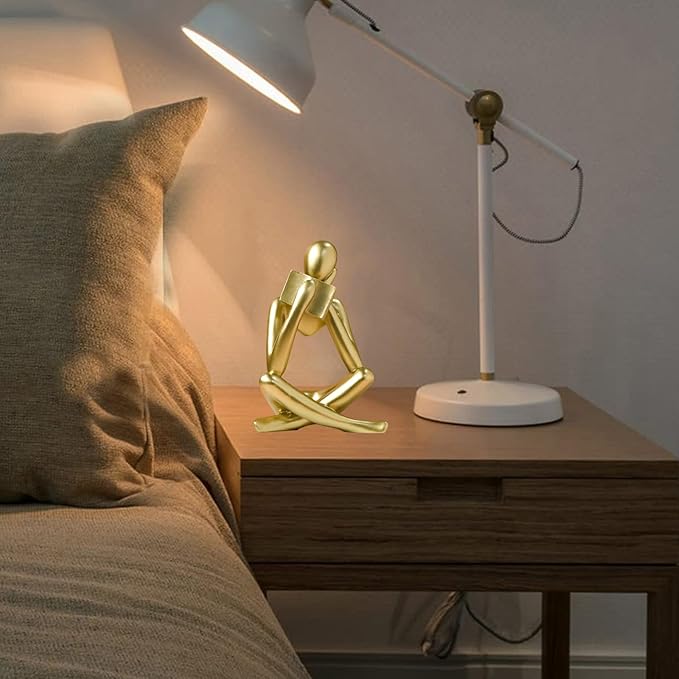 Gold resin reading figurine on nightstand, seated cross-legged with book support