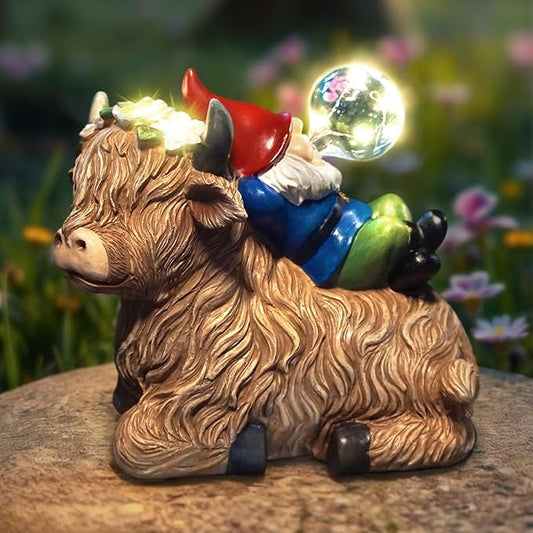 Solar highland cow gnome garden statue with red horns, blue overalls, glowing solar globe