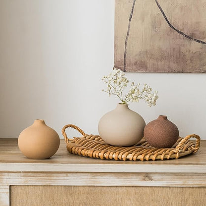 Set of 3 matte ceramic bud vases on a woven tray, one holding small flowers