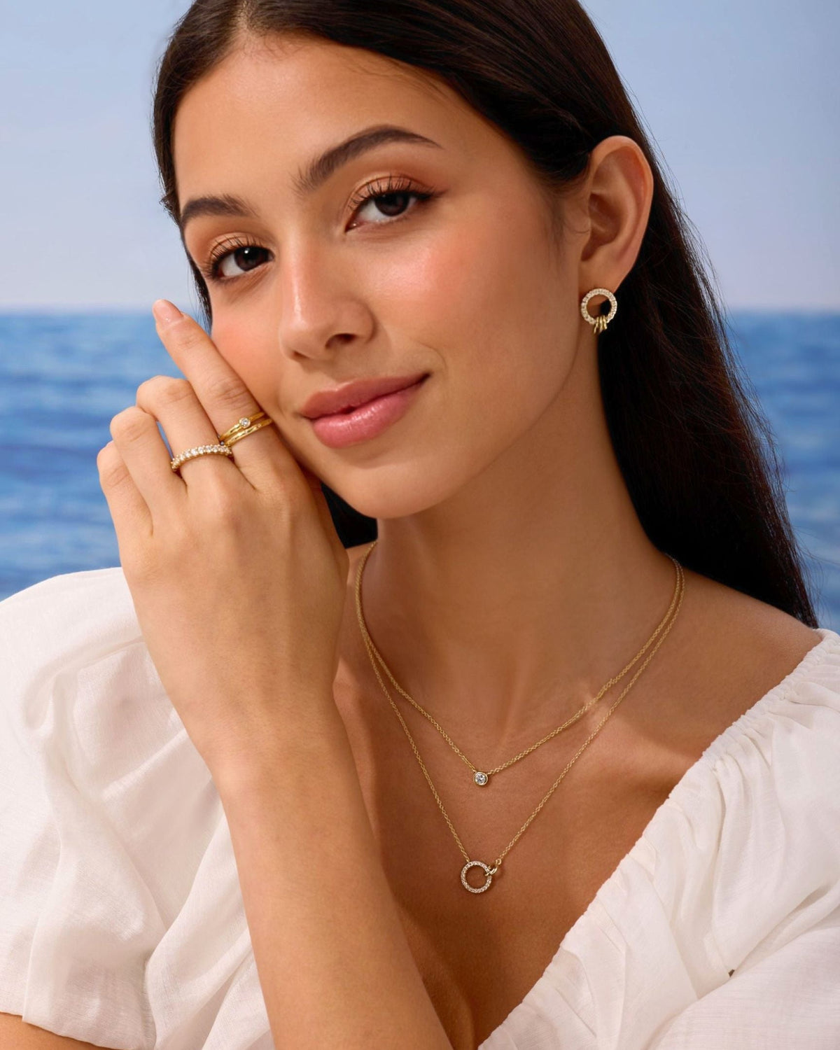 Gold open-circle pendant necklace worn at the collar, shown with a second chain