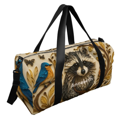 Black-strap duffel bag with raccoon face, blue bird, and leaf pattern print
