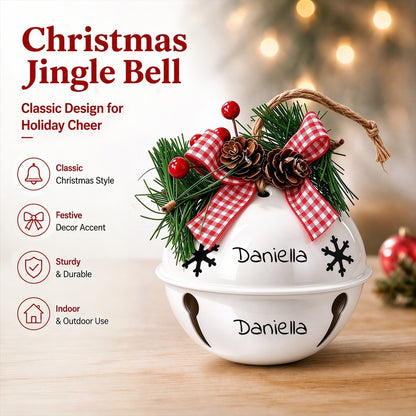 White holiday jingle bell ornament with red plaid bow, pine, pinecones, and ribbon loops