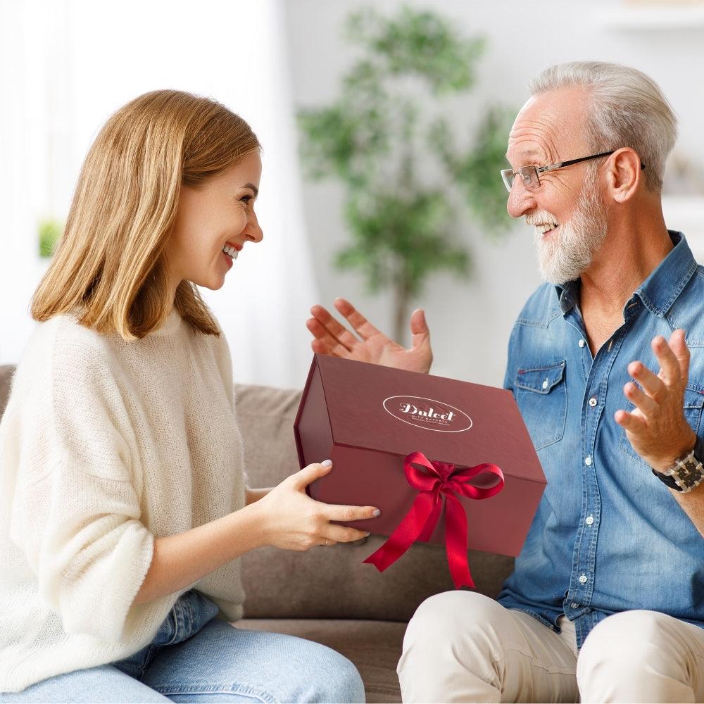 Dulcet gift box with red ribbon held by two people, smiling