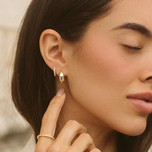 Gold hoop earrings on model, small oval hoops with studded detailing