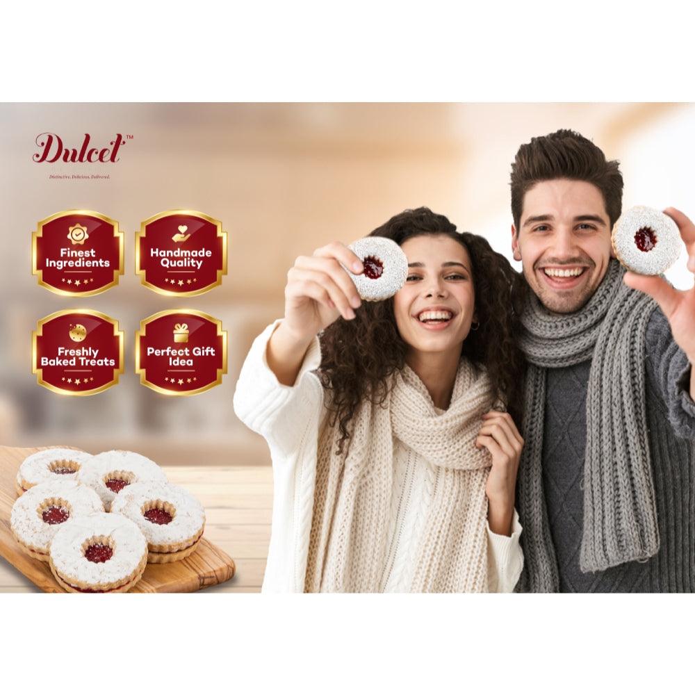 People holding round powdered cookies with red jam centers
