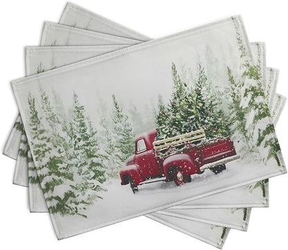 Set of four Christmas placemats featuring red pickup truck and pine trees in snow