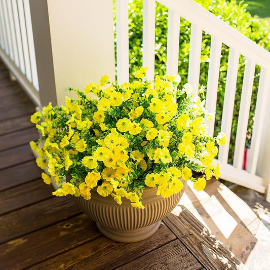 Yellow faux morning glory bundles with eucalyptus-style leaves in a round cream planter