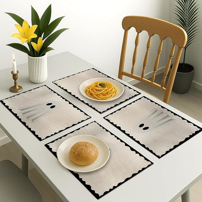 Set of four ghost placemats on dining table, off-white with scalloped black edges