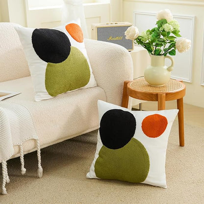 Tufted boho pillow cover with white background and black, olive-green, and orange circle design