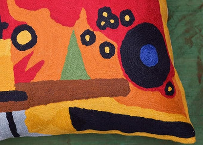 Close-up of red abstract embroidered pillow cover with blue and orange circle shapes
