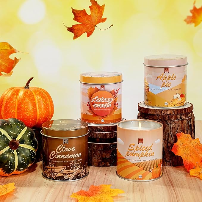 Assorted autumn scented candle jars with visible wicks on a tabletop