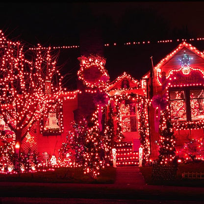 Red mini Christmas string lights on house and yard decorations