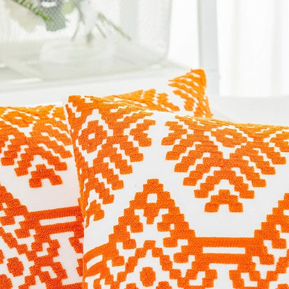 Orange embroidered throw pillow cover close-up with white diamond pattern