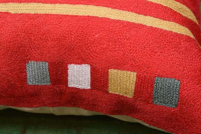 Red abstract pillow cover corner with multicolor small square accents