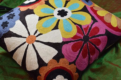 Embroidered floral pillow cover with daisy and blossoms in pink, blue, and orange