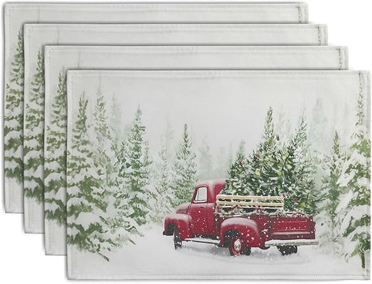 Set of four Christmas placemats with red truck and pine tree in snowy scene