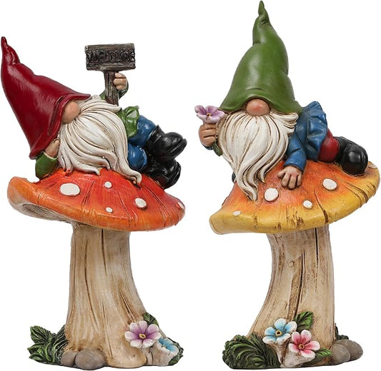 Two resin garden gnome statues with white beards, red and green hats, on mushroom bases.