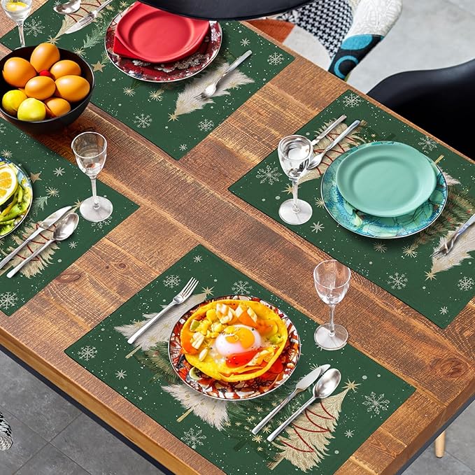 Green Christmas placemat squares with pine tree motifs and snowflakes on table