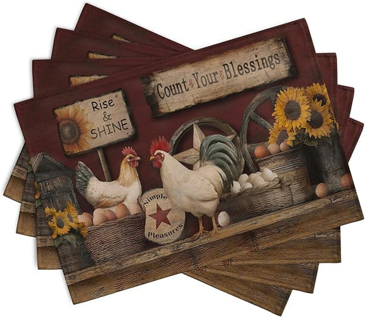 Four angled farmhouse placemats featuring rooster and sunflower artwork with red trim