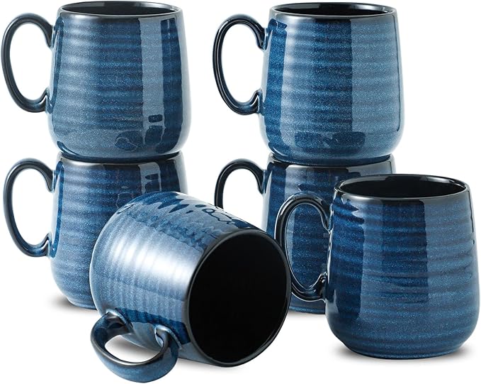Set of blue ceramic espresso cups with black interiors and curved handles