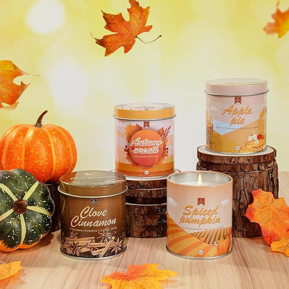 Set of autumn scented candles in metal tins and jar, with pumpkins and fall leaves
