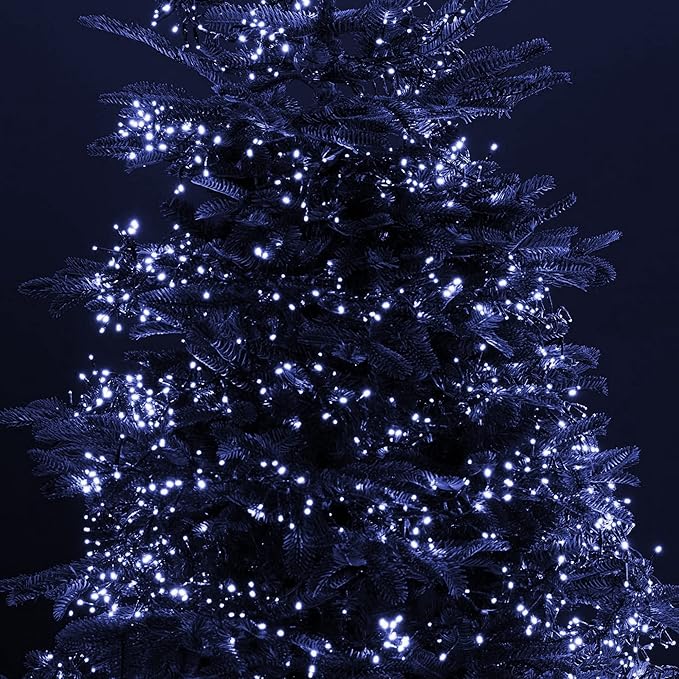 Christmas LED string lights wrapped on greenery with cool white bulbs on green wire