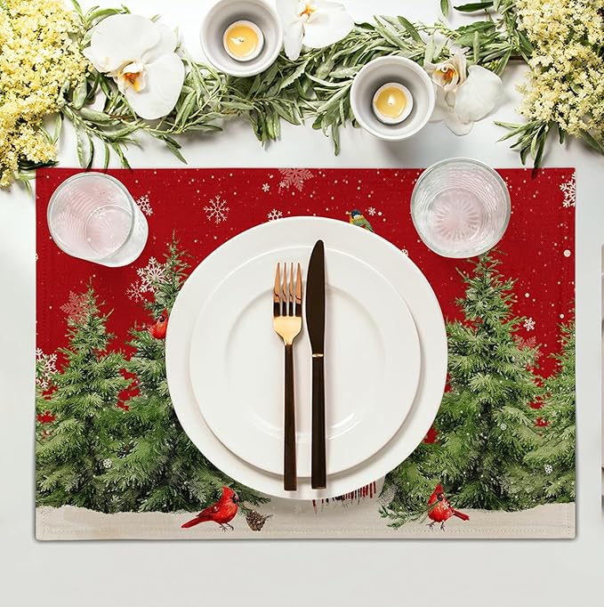 Red snowman holiday placemat with pine trees and cardinals under a dinner plate