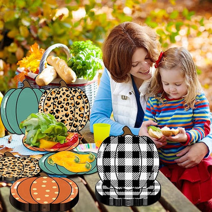 Pumpkin-shaped paper party plates with leopard, teal, and black-and-white plaid patterns