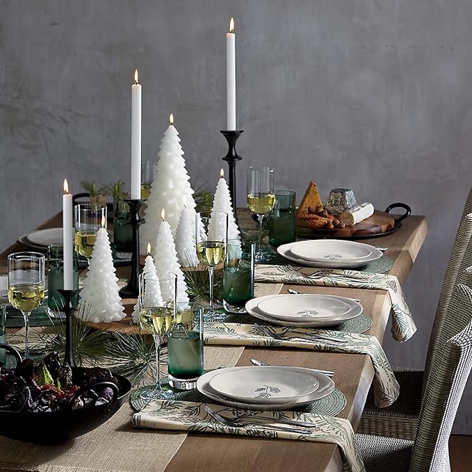 Black iron taper candle holders with lit tapers, staggered heights in a tabletop display