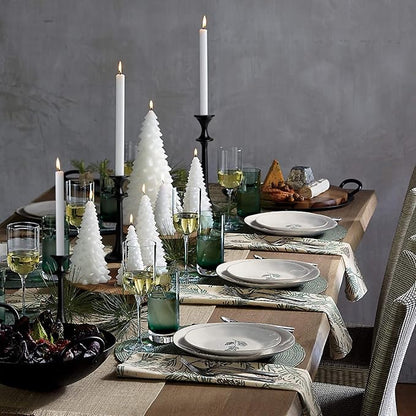 Black iron taper candle holders with lit tapers, staggered heights in a tabletop display