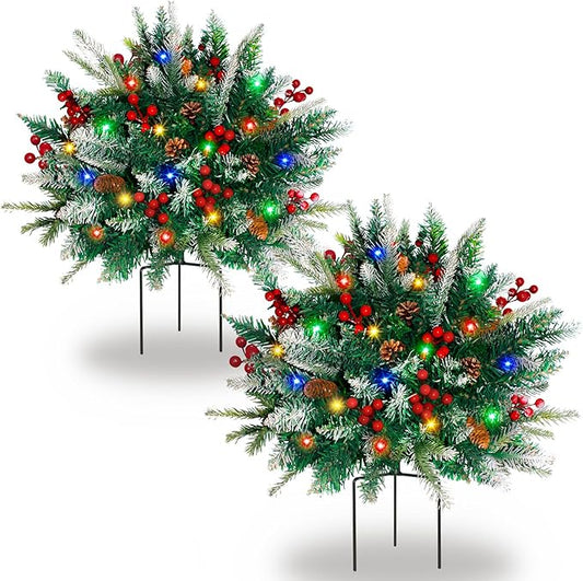 Two artificial pine tree urn fillers with multicolor LED lights and red berry accents