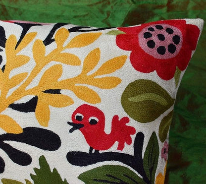 Close-up corner of floral bird pillow cover with yellow leaves and a red bloom.