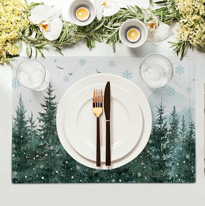 Set of 4 forest-themed placemats with pine trees and snowflakes, shown under a plate