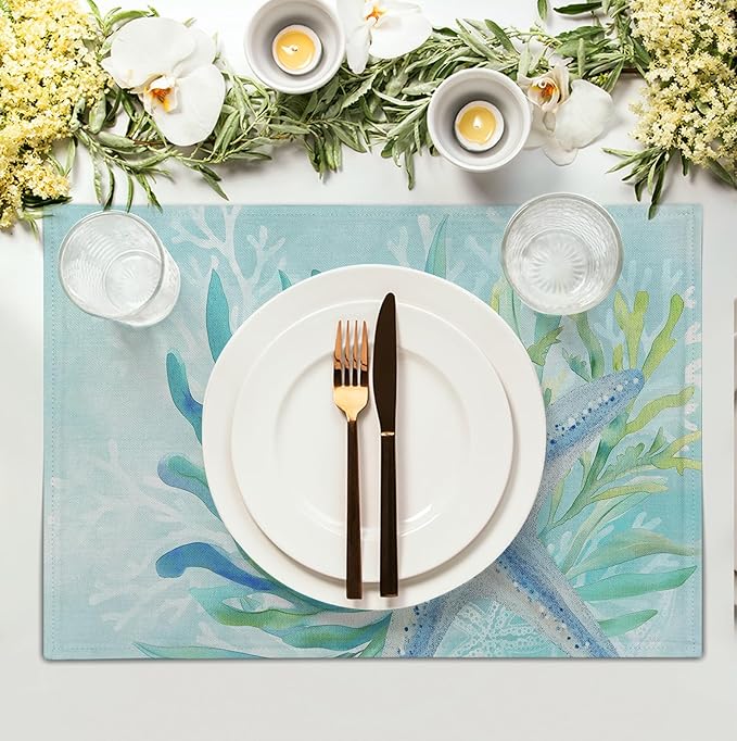 Teal blue cotton-linen placemat with starfish and seaweed print under a plate and cutlery