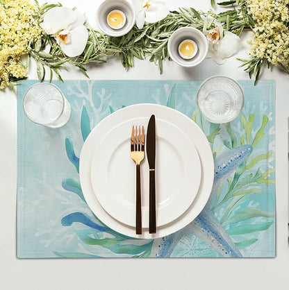 Teal blue cotton-linen placemat with starfish and seaweed print under a plate and cutlery