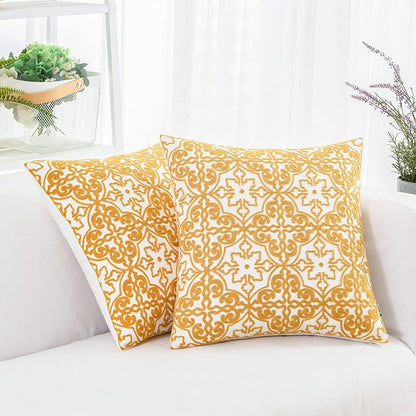 Mustard yellow and white embroidered throw pillow covers with ornate damask pattern