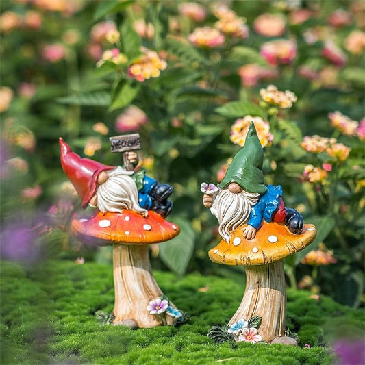 Pair of outdoor yard gnome statues standing on mushroom bases, with flowers at the feet.