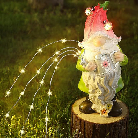 Outdoor resin garden gnome statue with red hat, watering can, and glowing solar fairy lights