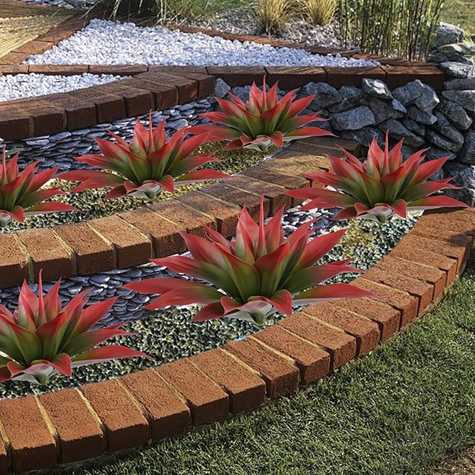 Cluster of wine-red faux agave plants with green centers in white planters