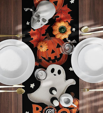 Black Halloween table runner with white ghost, jack-o-lantern pumpkins and orange spiderweb accents