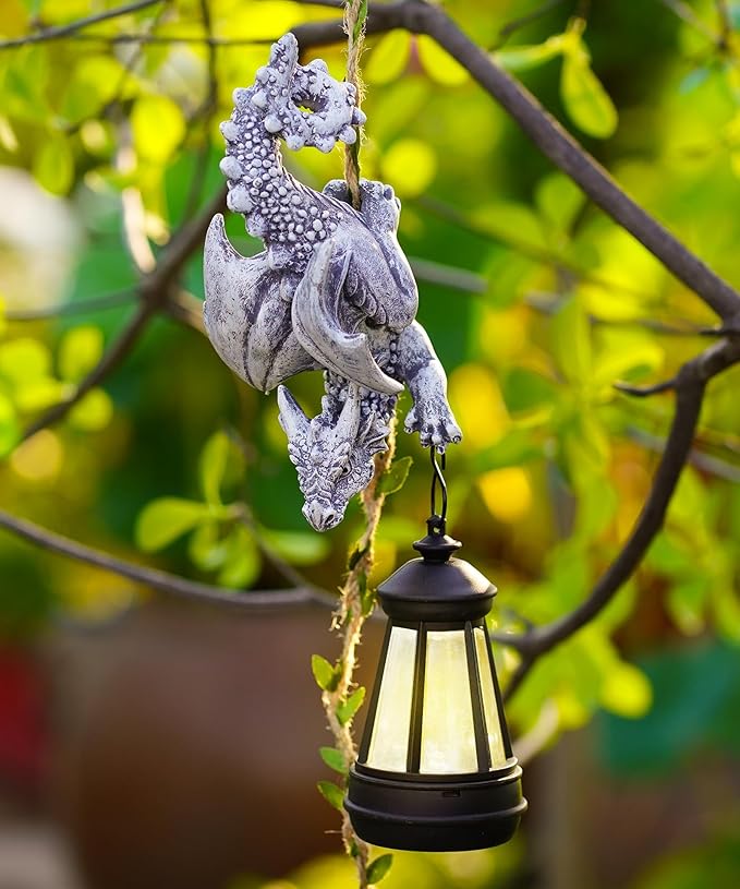 Stone-gray dragon garden ornament with hanging black lantern on a vine rope