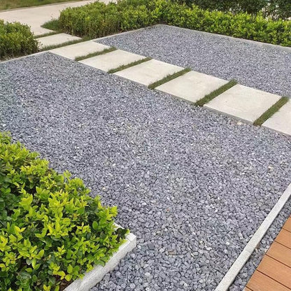 Gray stone gravel walkway with edging stones, stepping pads, and low plants