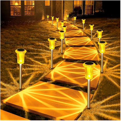 10-pack style solar stake lights with warm amber glow on metal rods along a path