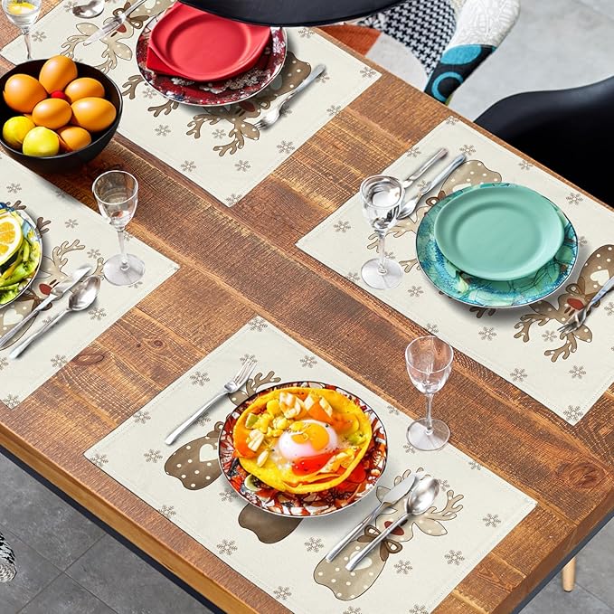 Reindeer snowflake placemats on table with dinner plates, cutlery, and drinks