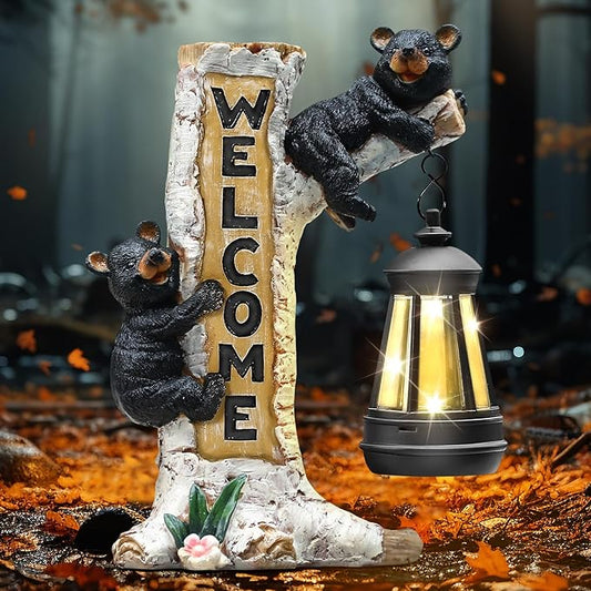 Black bear statue hugging a post with gold Welcome letters and a glowing solar lantern