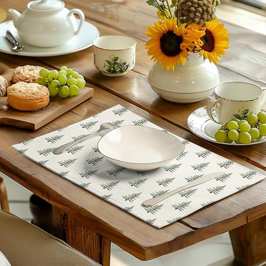 White cotton-linen placemat with green pine tree pattern on wooden dining table