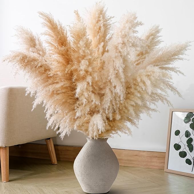 Natural dried pampas grass stems with fluffy tan plumes in a floor vase.